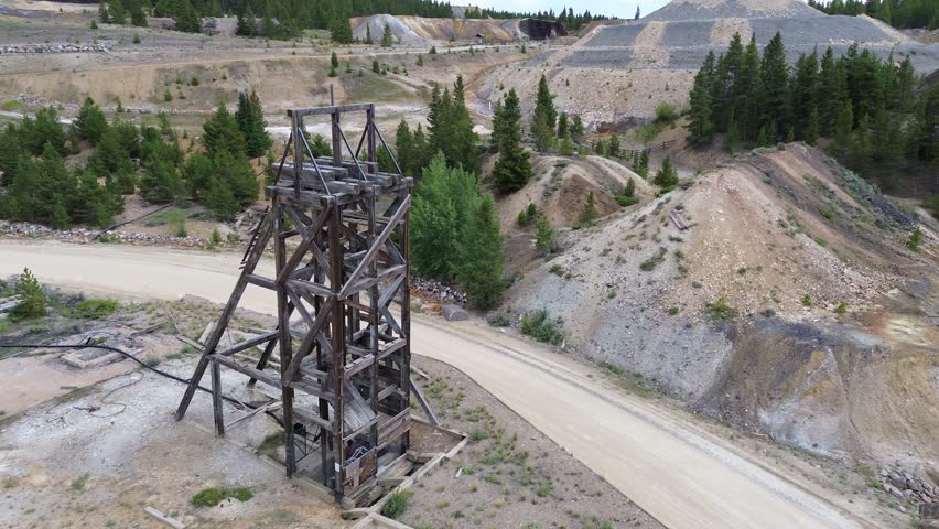 Abandoned mine ruins near Leadville, Colorado. Shot is a flyby wide angle shot of the structure and shows tailings and other ruins beyond.