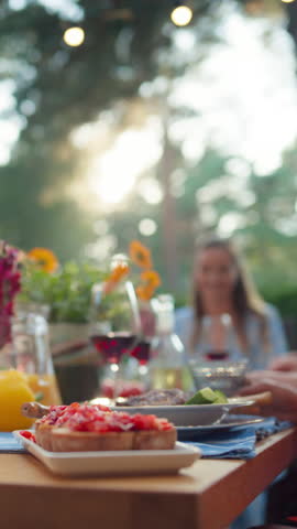 Vertical Screen: Parents, Children and Friends Gathered at a Barbecue Dinner Table Outside a Beautiful Home. Old and Young People Have Fun, Eat and Drink. Garden Party Celebration in a Backyard