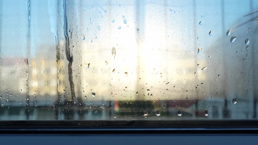 Condensation forming on double glazed window. Contrast cold air and humidity. Drops on glass. Cold room. Backlight poor glass sealing