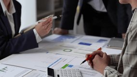 Business professionals collaborating, analyzing financial charts, and discussing growth strategies in a dynamic office setting - Powered by Shutterstock - Get 15% off with code: PIKWIZARD15