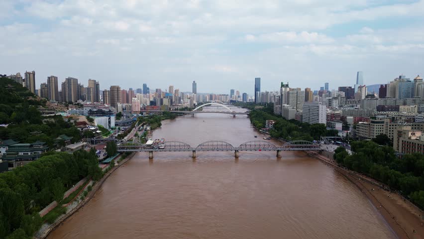 Lanzhou, China: Aerial drone footage of a speed boat sailing on the Yellow river under the Zhongshan bridge in Lanzhou, the main city of Gansu province in China. 