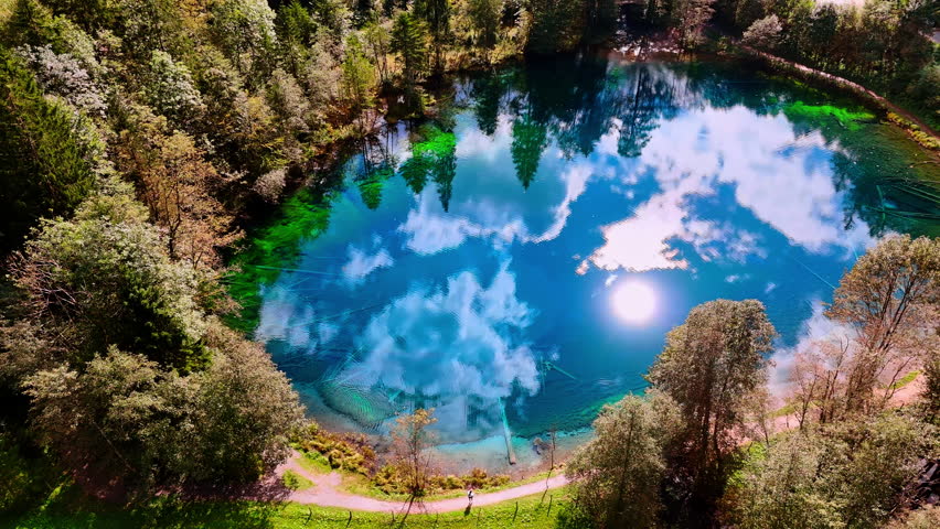 Rising above a little lake reflecting azure sky on sunny day. Stunning view of the Christlessee lake, Oberstdorf, in the Bavarian Alps, Europe.