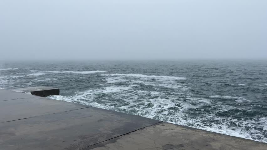 Urban Coastline in Fog: Gentle Sea Waves