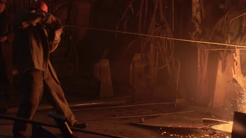 Forging Metal in an Industrial Workshop with Flying Sparks and Vibrant Energy All Around. Stock Clip