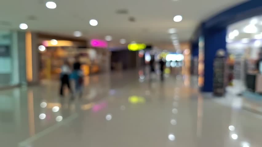 blur of people walking in airport terminal. defocused airport activity in morning. The video emphasizes the movement and activity typical of busy travel environments.