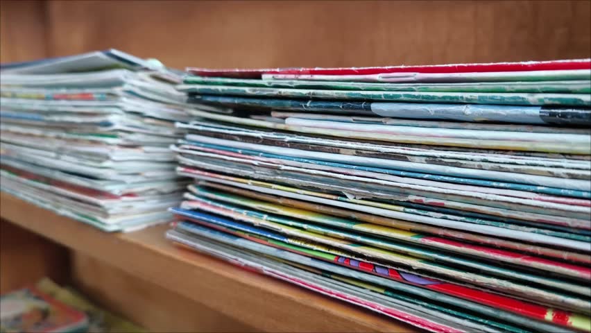 Closeup view 4k video footage of old paper texture of many old stacked magazines. A stack of old magazines.