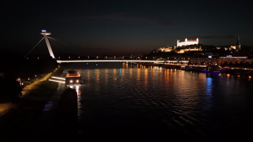 Drone video, river Danube with the view of SNP Bridge and Bratislava cstle in the nigh. Bratislava, Slovakia, Europe.
