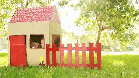 Video of happy little children sitting in playhouse