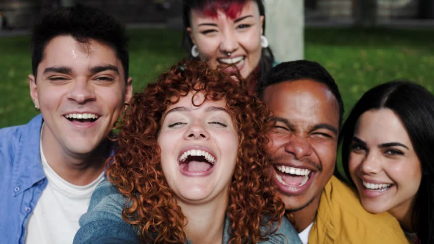 Happy group of people taking self picture smiling at camera at park city. Young diverse friends having fun together outside