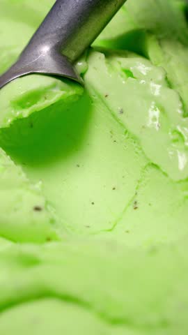 Close-up of green gelato being scooped. Concept of frozen sweet foods.