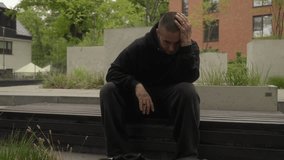 A tattooed man with piercings sits on steps and nodding to music. His confident, rebellious expression, tough demeanor, and intense gaze reflect a dominant, defiant personality, embodying street style - Powered by Shutterstock - Get 15% off with code: PIKWIZARD15