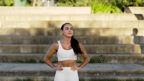 Active woman pausing after workout, hands on hips as catches breath. Determined jogger resting post run, gazing into distance - Powered by Shutterstock - Get 15% off with code: PIKWIZARD15