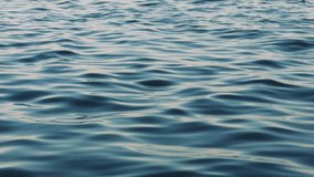 Gentle waves ripple across a deep blue water surface, highlighting nature's beauty and power. The dynamic movement creates a tranquil and serene atmosphere - Powered by Shutterstock - Get 15% off with code: PIKWIZARD15
