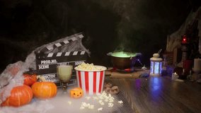 Halloween Scene: Film Clapperboard, Watching a Scary Horror Movie. Popcorn from the Cinema Theater. Witch’s Cauldron Brewing a Glowing Magic Potion. Pumpkins, Mist, Smoke, and Spiders, Poisonous Snake - Powered by Shutterstock - Get 15% off with code: PIKWIZARD15