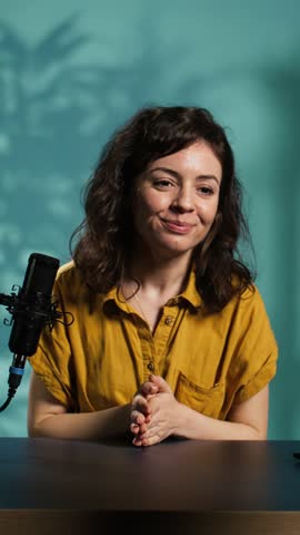 Vertical video Happy online show host hitting the record button on professional camera, using microphone to talk about today video topic with subscribers. Cheerful influencer filming creative vlog