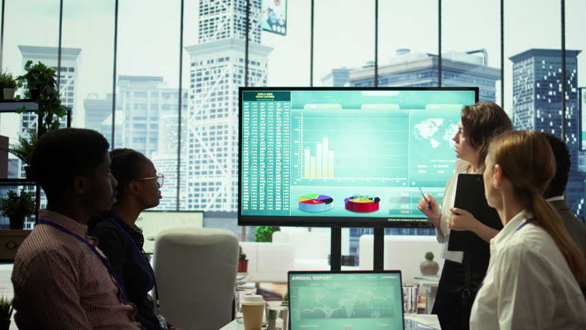 Corporate associates looking into project details and timetables in conference room, establishing budget and operations to accomplish objectives in a competitive business environment. Camera B.