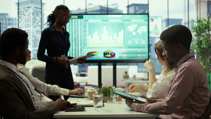 Diverse work team collaborating on project management tasks, utilizing smart technology and detailed analytics to optimize resource allocation and ensure enterprise objectives. Camera B.