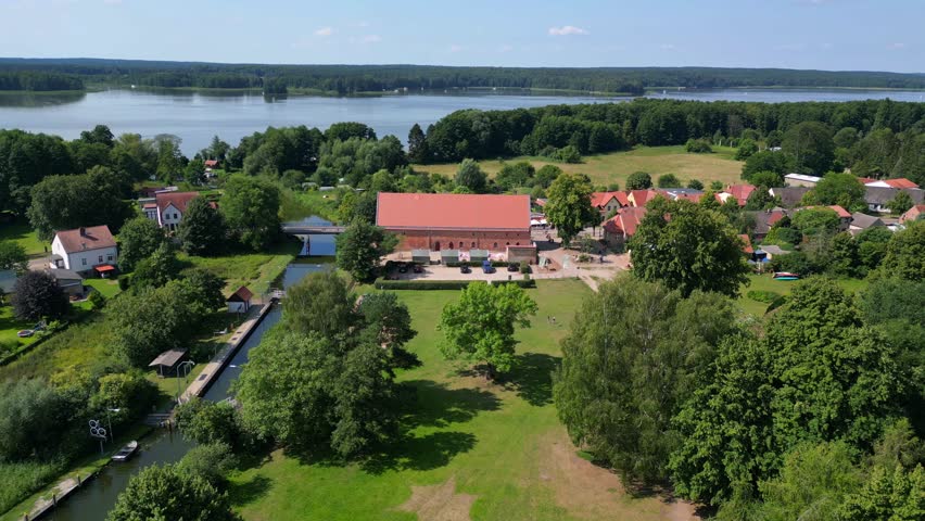 canal lock sluice being used by boats on a sunny summer day in germany Himmelpfort countryside Brandenburg. Magic aerial view flight fly reverse drone