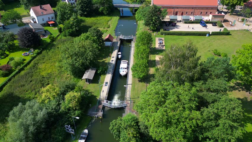 canal lock sluice being used by boats on a sunny summer day in germany Himmelpfort countryside Brandenburg. Unique aerial view flight
