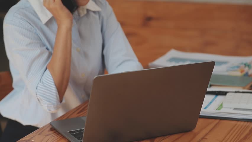 Asian Businesswoman Working on Financial Reports With a Laptop and Calculator in the Office, Conducting Business Planning, Financial Analysis, and Strategic Investment Development for Long Term