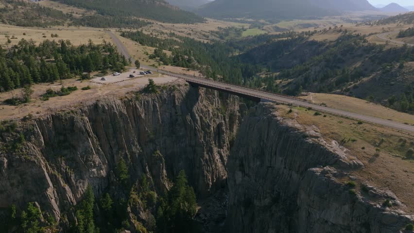 Aerial orbit to left over Sunlight Creek Bridge in Wyoming, showing the bridge crossing the rugged canyon and the wilderness around it