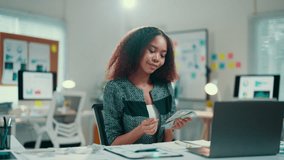 African american businesswoman is counting money she earned from her successful startup company. She is smiling and happy with her achievements - Powered by Shutterstock - Get 15% off with code: PIKWIZARD15