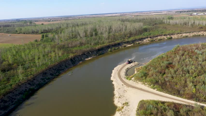   Aerial view of illegal exploitation of river sand and gravel with excavator on river bank by drone