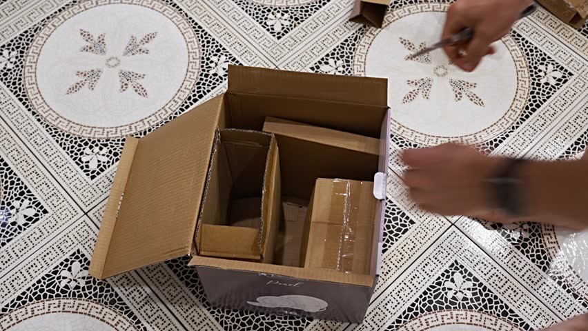 A man unpacks a box with a new set of tableware. Checking the purchase from the online store.