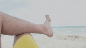 Serene slow-motion POV: Man's bare foot rests on knee, framed against tranquil beach. Gentle waves lap sandy shore as sea meets pale sky. Captures essence of carefree vacation relaxation.
 - Powered by Shutterstock - Get 15% off with code: PIKWIZARD15