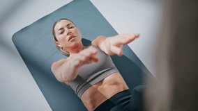 Fitness lady making crunches lying on yoga mat closeup. Athlete woman raising legs touching with hand training at gym. Sport girl lifting toe working out abs exercise for stomach muscles at carpet  - Powered by Shutterstock - Get 15% off with code: PIKWIZARD15