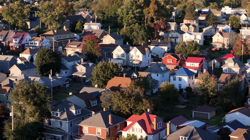 A forward dusk aerial establishing shot view of a typical Western Pennsylvania neighborhood in the early autumn season.
