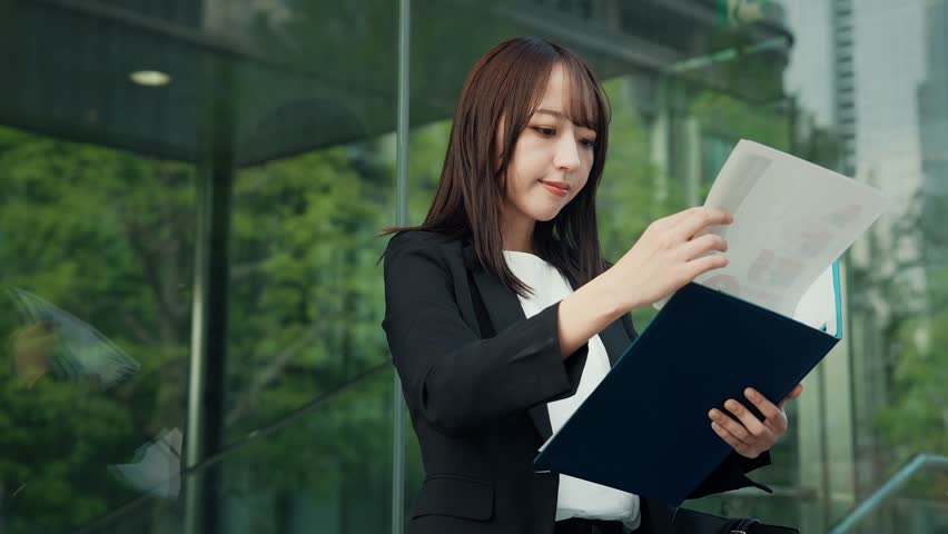 Business data concept with woman looking at documents in the city