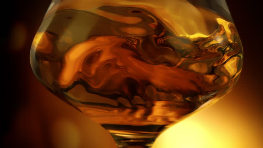Super Slow Motion Detail Shot of Swirling Golden Alcohol in Glass at 1000fps.