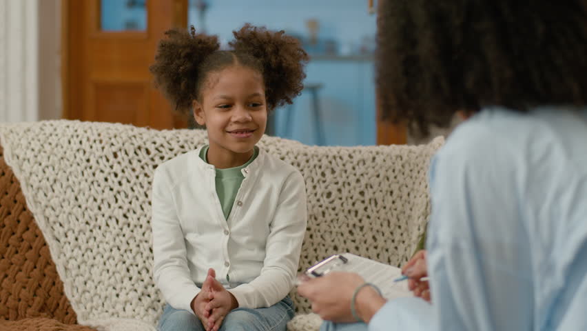 African American happy child tell doctor talk explain consent yes smile psychologist friendly recovery health pleasant communication appointment home little girl kid daughter consultation relations