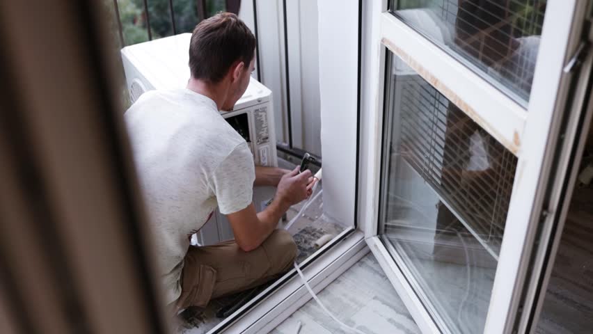 Repairman fix air conditioning systems, Male technicians service for repair and maintenance of air conditioners, Air conditioning technicians install new air conditioners at home