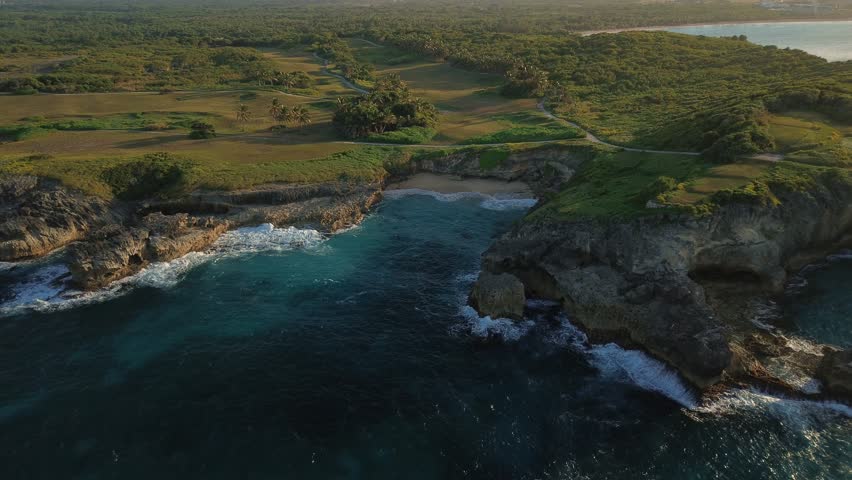 Aerial view of rocky coastline of Dominican Republic at sunset. Rugged cliffs and Atlantic Ocean