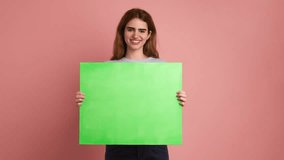 Smiling young woman holding a green board - Powered by Shutterstock - Get 15% off with code: PIKWIZARD15