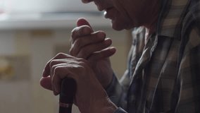 an elderly person 70-79 years old coughs while sitting holding a walking stick, a pensioner coughs heavily into his fist while inside - Powered by Shutterstock - Get 15% off with code: PIKWIZARD15