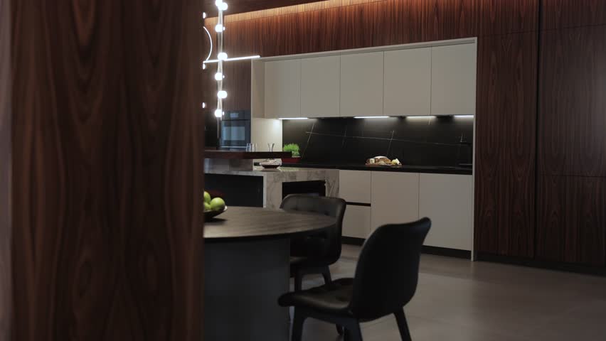 A modern kitchen interior design featuring elegant lighting and a sophisticated minimalist style