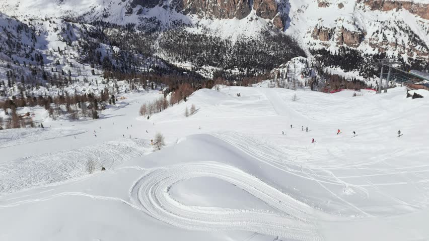 Aerial reveal of mountain view with skiers skiing, Cortina D'ampezzo ski resort