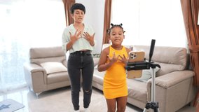 Happy family Mother and little daughter spending time together at home. Mom and child girl kid enjoy and fun indoor lifestyle using smartphone live streaming dancing on social media in living room. - Powered by Shutterstock - Get 15% off with code: PIKWIZARD15