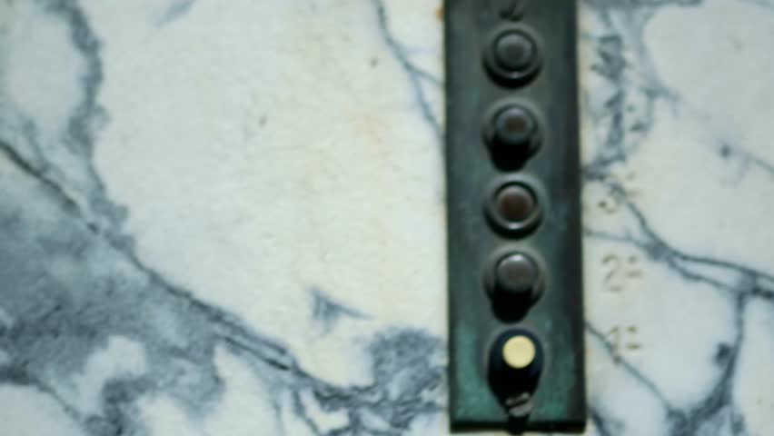 A close-up of a marble wall with a door bell on it