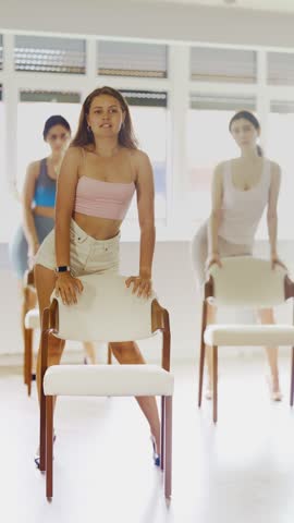 Slender women rehearse modern dances using a chair. High quality 4k footage