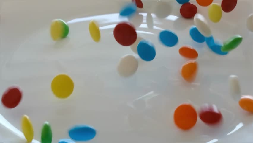Falling colorful chocolate candies on a white background