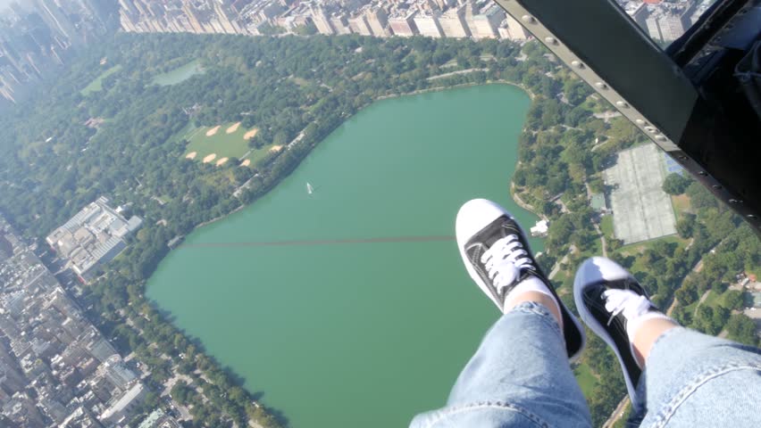 New York City doors off helicopter flight, heli flying over Manhattan, United States. Feet in sneakers, legs in shoes selfie pov. Extreme tourist adventure, travel USA. Camera shaking. Central Park. - Powered by Shutterstock - Get 15% off with code: PIKWIZARD15