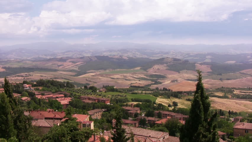 Italy. Tuscany. The view from the hill to the village, fields, mountains and