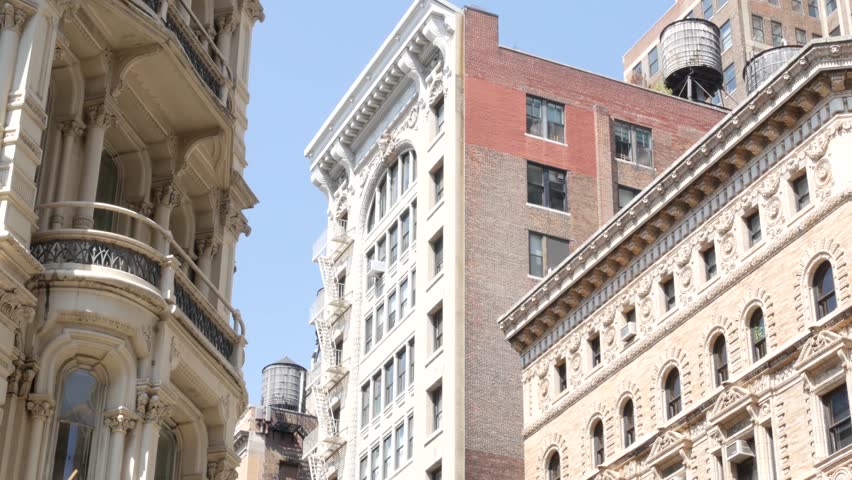 New York City Broadway, Manhattan midtown classic building corner architecture. Urban residential house exterior. Real estate property in USA. Typical brick facade. Rooftop water tower, tank on roof.