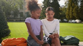 Little kids girls female children friends multiracial ethnic sisters African American Indian schoolgirls pupils elementary students gadget addict using phone shocked amazing news outdoors school yard - Powered by Shutterstock - Get 15% off with code: PIKWIZARD15