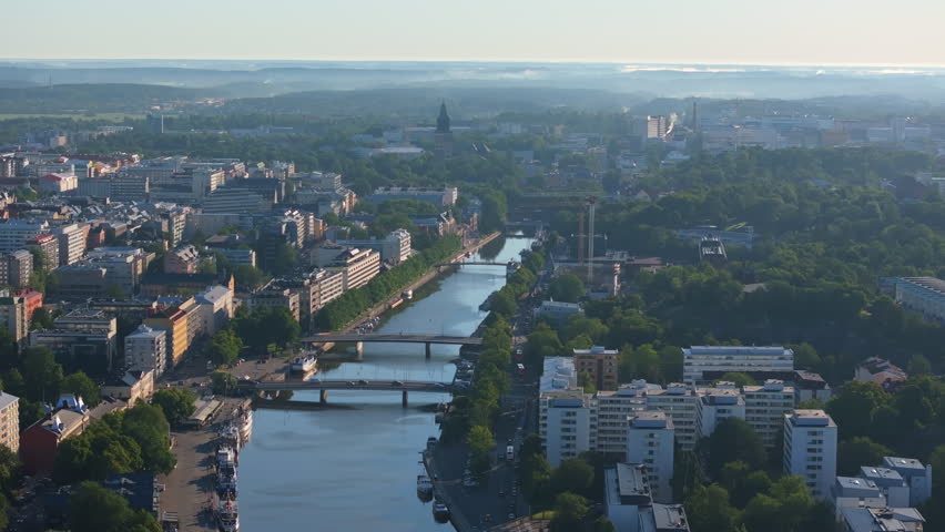 Aerial views showcase Turku, Finland, highlighting the Aura River winding through the city center. Boats line the riverbanks, while a bridge connects both sides