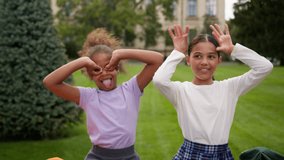 Happy little girls two kids schoolgirls children school education students pupils classmates multiracial African Indian female friends laugh have fun eyes circles grimace play game kidding outdoors - Powered by Shutterstock - Get 15% off with code: PIKWIZARD15